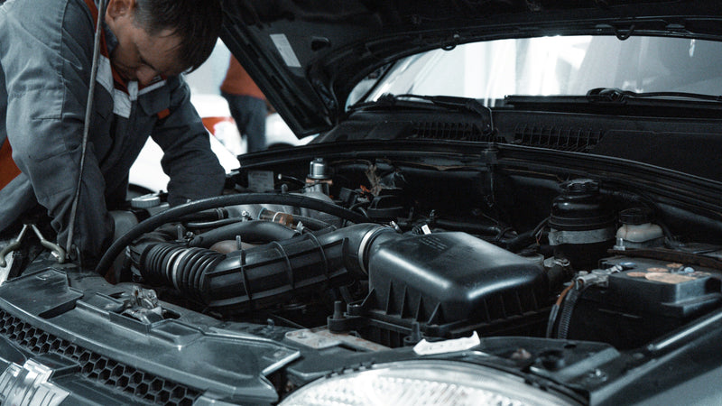 Photo of a mechanic fitting a battery into a car